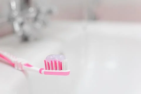 Pink toothbrush with toothpaste. Small depth of field. Stock Photos