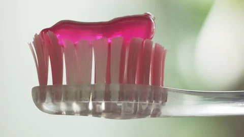 Pink toothpaste on old used toothbrush. Stock Footage 129469087