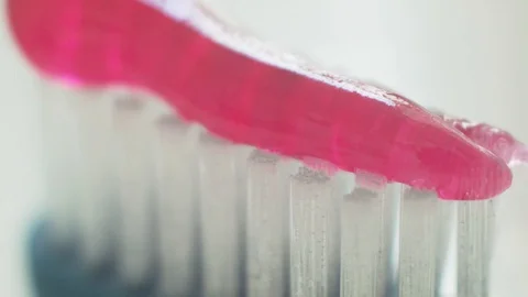 Pink toothpaste on toothbrush macro Stock Footage 129468987