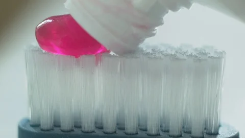 Pink toothpaste on toothbrush macro. Stock Footage 129469042