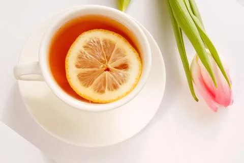 Pink tulip with a cup of tea on a light background, copy space. Postcard fo.. Stock Photos