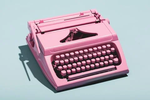 Pink typewriter on a blue pastel background. Stock Photos