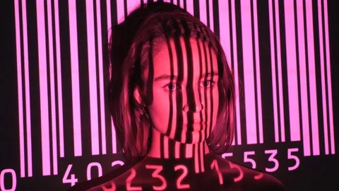 Pink UPC code projected onto attractive young womans face. Stock Footage