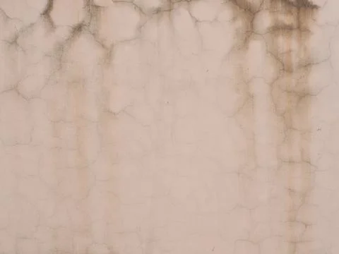 Pink wall with a pattern of cracks and vertical brown smudges. Not seamless Stock Photos