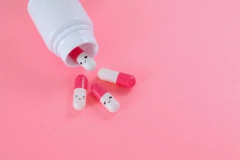Pink white pills fall out of the bottle close up on pink background. Choose your Stock Photos
