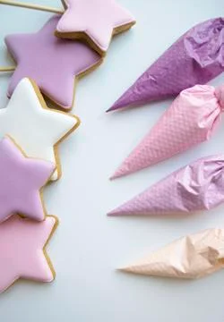 Pink, white, purple stars next to pastry bags filled with icing Stock Photos