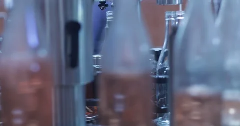 Pink wine bottles going through band towards packaging Stockbeeldmateriaal 94928704