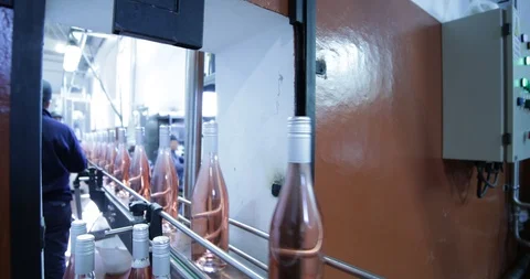 Pink wine bottles going through band towards packaging Stockbeeldmateriaal 94932212