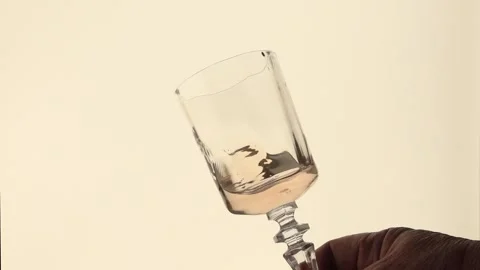 Pink wine moves in waves and splashes in a clear wine glass Stock Footage 327098026