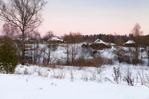 Pink winter sunset under rustic houses Stock Photos
