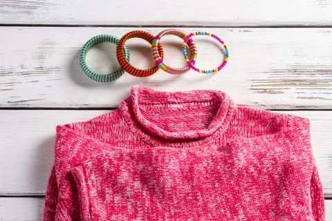Pink wool pullover and bracelets. Stock Photos