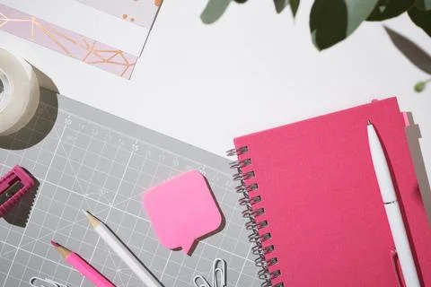 Pink workspace flat lay with notebook and clips for creative planning on wh.. Stock Photos