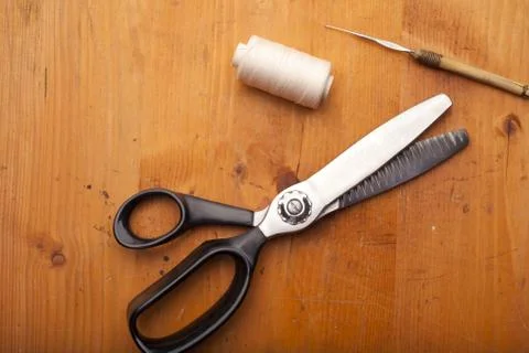 Pinking shears with spool and Crochet tool craft concept on wooden texture Stock Photos