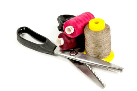 Pinking shears with three reels of colored cotton Stock Photos