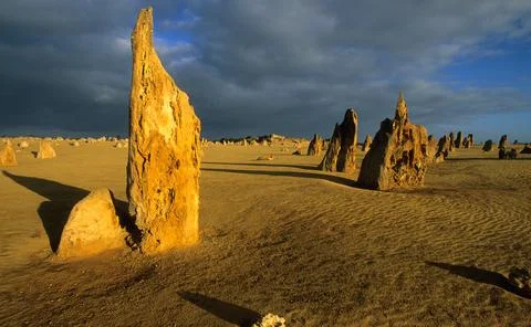 Pinnacles desert landscape at sunset with dramatic clouds. Stock Photos