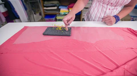 Pinning together plastic wrap with textile before cutting Stock Footage 41013243