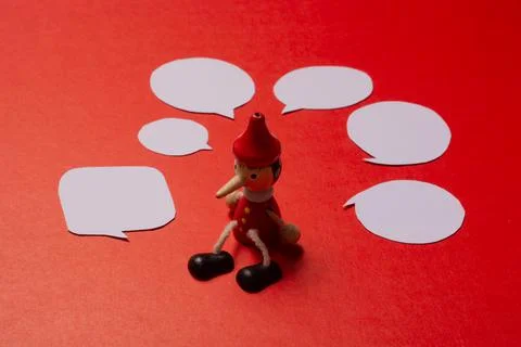 Pinnochio with Mini speech bubbles cut out of paper around Stock Photos
