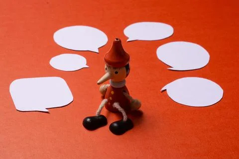 Pinnochio with Mini speech bubbles cut out of paper around Stock Photos