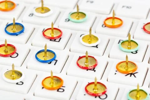Pins on computer keyboard Pins on computer keyboard - concept background C... Stock Photos