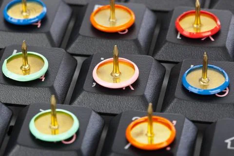 Pins on computer keyboard Pins on computer keyboard - concept background C... Stock Photos