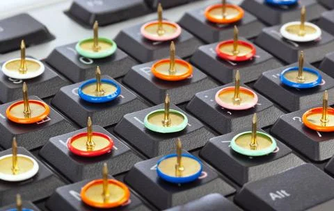 Pins on computer keyboard Pins on computer keyboard - concept background C... Stock Photos