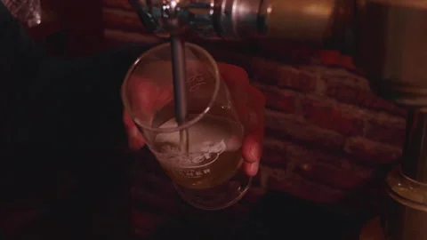 A pint of Carlsberg being pulled poured into a glass in an Irish pub. Stock Footage 302886088