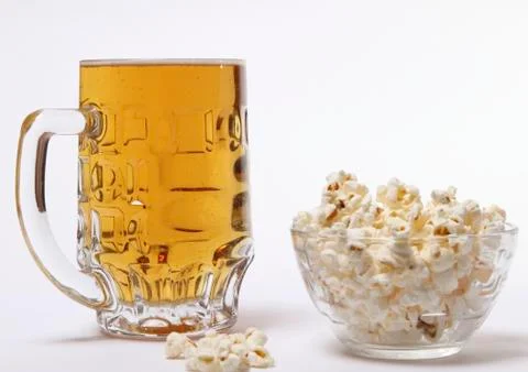 Pint of cold light beer and salty popcorn Stock Photos