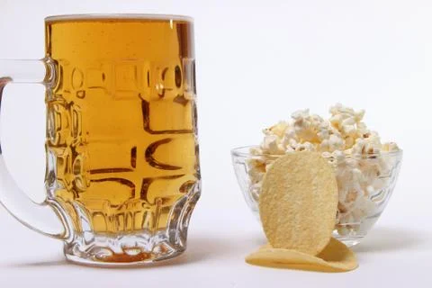Pint of cold light beer and salty popcorn Stock Photos