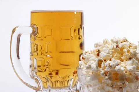 Pint of cold light beer and salty popcorn Stock Photos