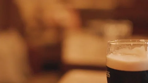 Pint of Dark Beer on Pub Table in Warm Light Stock Footage 315545999