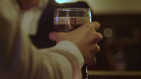 A pint of Guinness is placed on the bar to settle Stock Footage 235437117