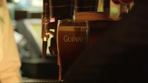 A pint of Guinness settles on the bar counter Stock Footage 235437314