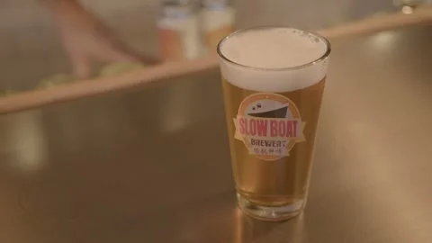 Pint of Light Beer on Bar Counter in Beijing Pub with Cans in Background Stock Footage 345757796