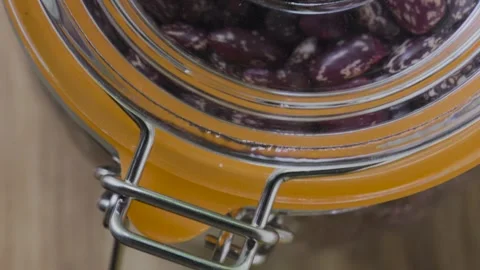 Pinto beans on table to jar lid ending on toggle clamp macro, 4K Stockbeeldmateriaal 341712007