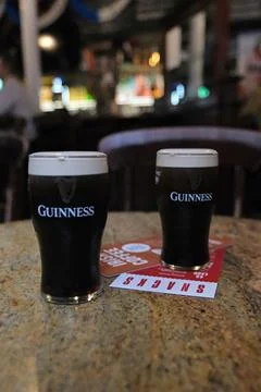 Pints of Guinness on Granite Table inside a Belfast Pub Stock Photos