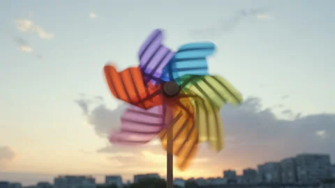 Pinwheel rotating colored plastic with blowing wind against blue sky Stock Footage 132125404