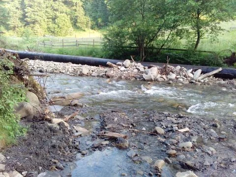 Pipe and mountain river Stock Photos