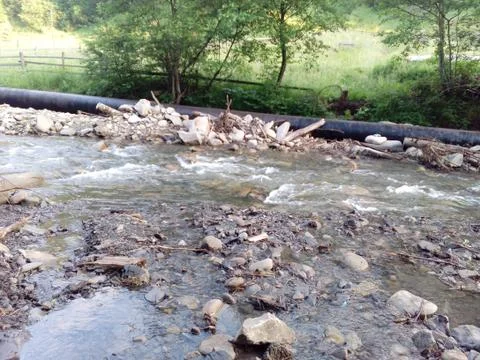 Pipe and mountain river stream Stock Photos