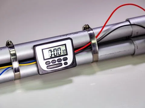 Pipe bomb with an clock timer to trigger detonation on white background Foto stock