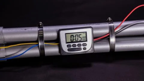 Pipe bomb with an clock timer to trigger detonation on black background Stockfoto's