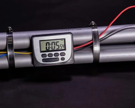 Pipe bomb with an clock timer to trigger detonation on black background Stockfoto's