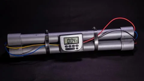 Pipe bomb with an clock timer to trigger detonation on black background Foto stock