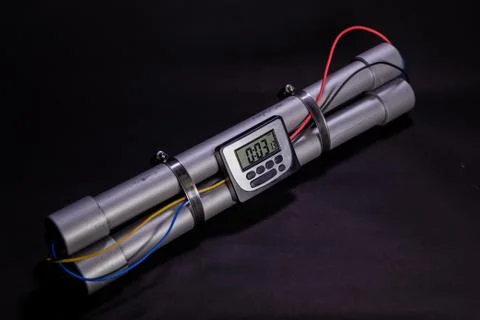 Pipe bomb with an clock timer to trigger detonation on black background Foto stock