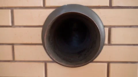 Pipe in a brick wall for connecting a fireplace stove Stock Footage 310764594