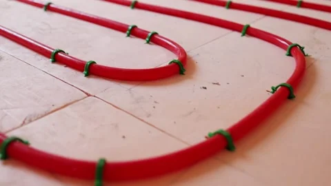Pipe clips for underfloor heating installation workers fixing plastic pipes Stock Footage 315507595