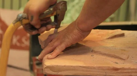 Pipe maker cuts shape of pipe and begins filing it smooth Stock Footage 8830688