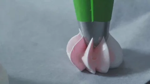 Pipe the meringue out onto the prepared baking sheet using a star tip Stock Footage 69205113