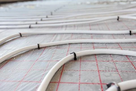 Pipe system of floor heating mounted in residential building under constructi Fotos de archivo