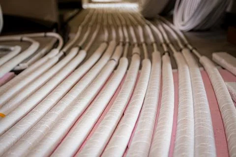 Pipe system of floor heating mounted in residential building under constructi Fotos de archivo