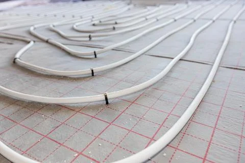 Pipe system of floor heating mounted in residential building under constructi Fotos de archivo